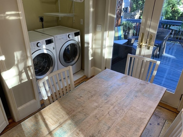 clothes washing area with laundry area, baseboards, and washer and dryer