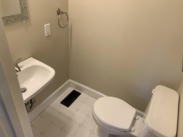 bathroom with tile patterned flooring, a sink, toilet, and baseboards