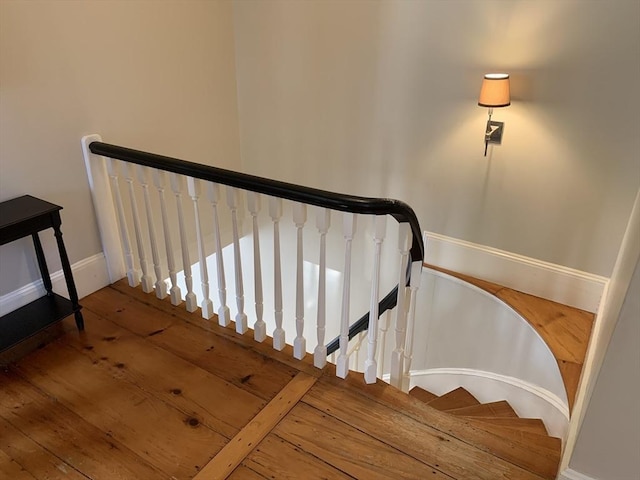 stairway featuring baseboards and hardwood / wood-style floors