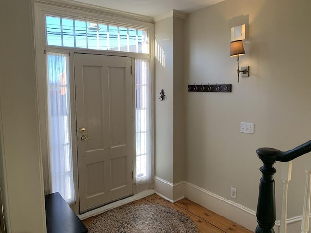 foyer featuring stairs and baseboards