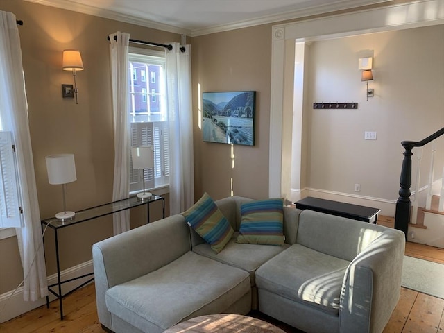 living area with light wood finished floors, baseboards, stairway, and crown molding