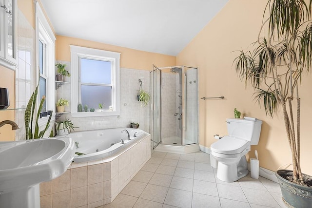 full bathroom featuring toilet, a sink, a jetted tub, tile patterned floors, and a stall shower