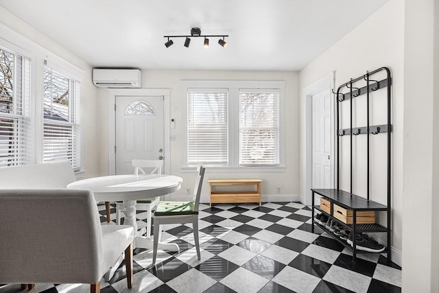 dining room with dark floors, baseboards, track lighting, and a wall mounted AC