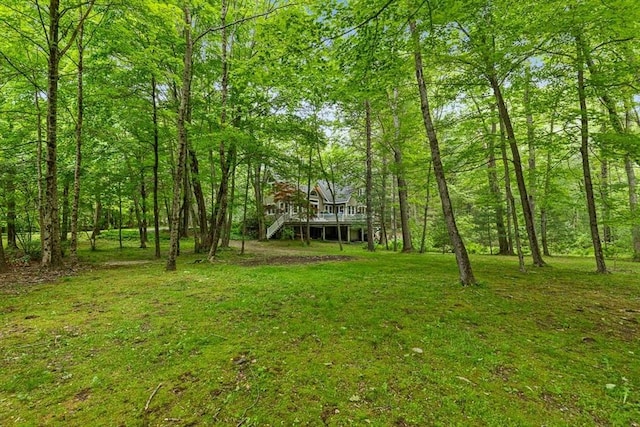 213 N Worcester St, Norton, MA 02766 - view of green lawn featuring a wooden deck, stairs, and a wooded view
