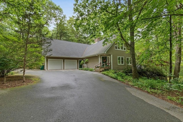 213 N Worcester St, Norton, MA 02766 - view of front of house featuring a garage, asphalt driveway, a chimney, and roof with shingles