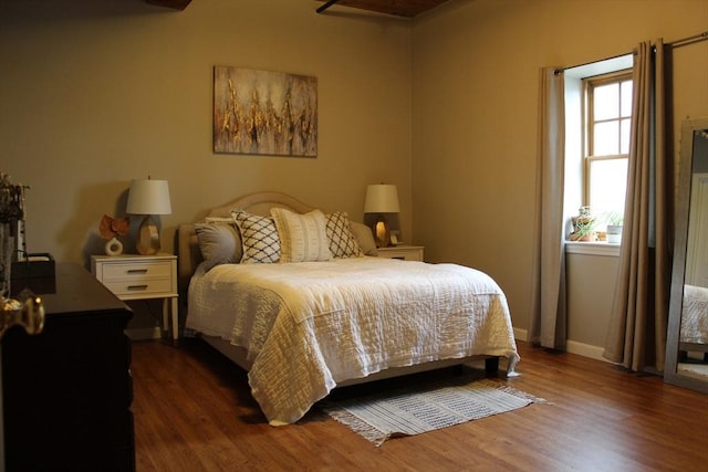 bedroom featuring wood finished floors and baseboards