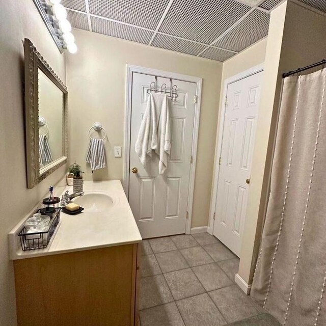 bathroom with tile patterned floors, baseboards, and vanity