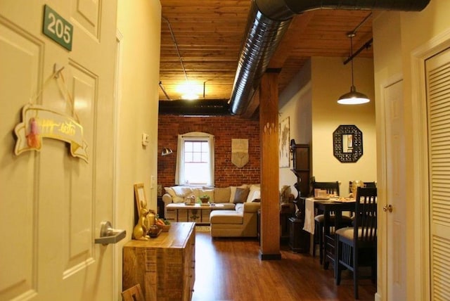 interior space featuring brick wall and dark wood finished floors