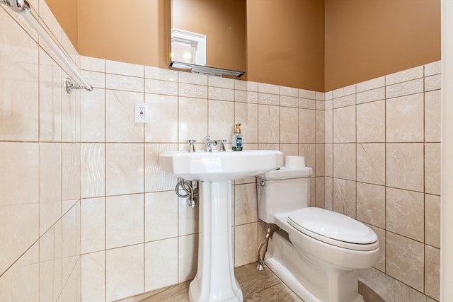 bathroom with tile walls, sink, and toilet