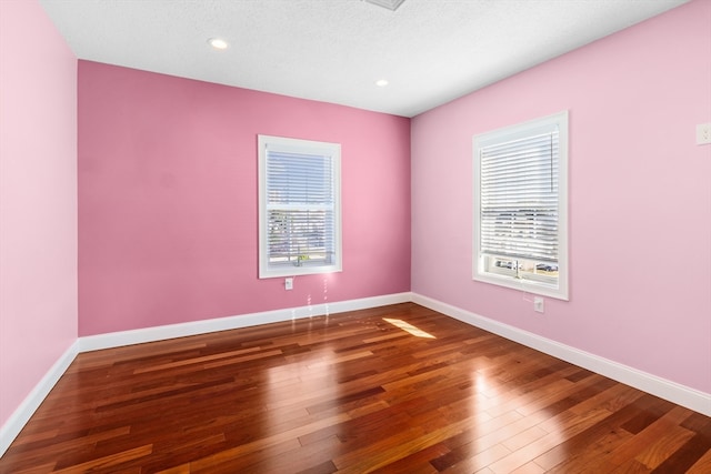 spare room with a textured ceiling and hardwood / wood-style floors