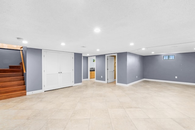 basement with light tile patterned flooring and a textured ceiling