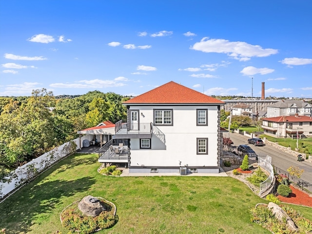 rear view of house featuring a deck and a lawn