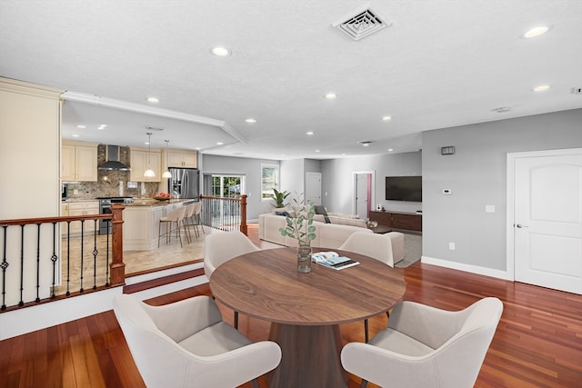 dining area with wood-type flooring and a textured ceiling