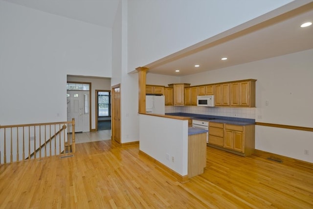 24 High Pines Cir Unit 24, Wilbraham, MA 01095 - kitchen with white appliances, light wood finished floors, tasteful backsplash, dark countertops, and recessed lighting