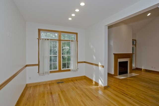 24 High Pines Cir Unit 24, Wilbraham, MA 01095 - empty room with wood finished floors, recessed lighting, a fireplace with flush hearth, and baseboards