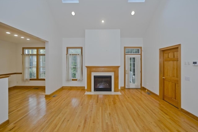 24 High Pines Cir Unit 24, Wilbraham, MA 01095 - unfurnished living room with light wood-style floors, a fireplace with flush hearth, recessed lighting, a high ceiling, and baseboards