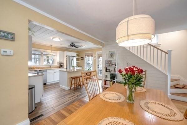 dining room featuring light wood-style floors, plenty of natural light, and ornamental molding