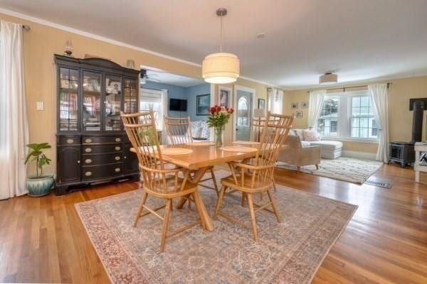 dining room with a wood stove and wood finished floors