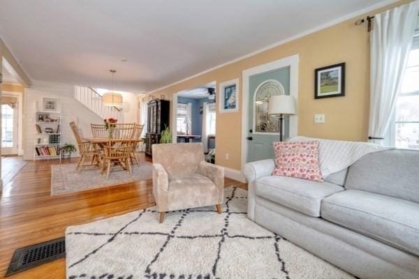 living room featuring visible vents, baseboards, and wood finished floors