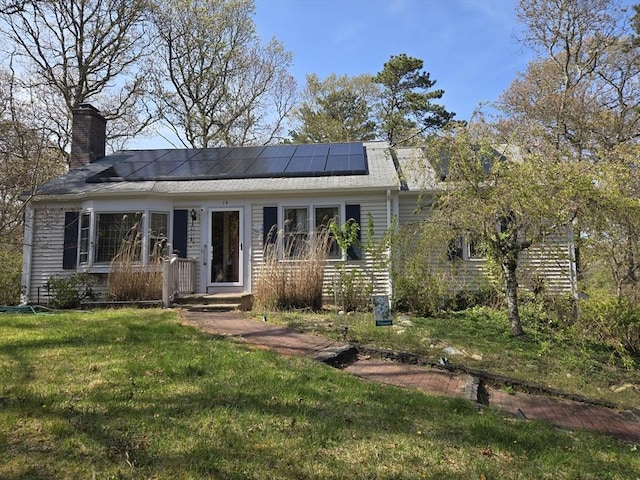 14 Many Oaks Cir, Yarmouth, MA 02675 - view of front of house with a front lawn, roof mounted solar panels, and a chimney