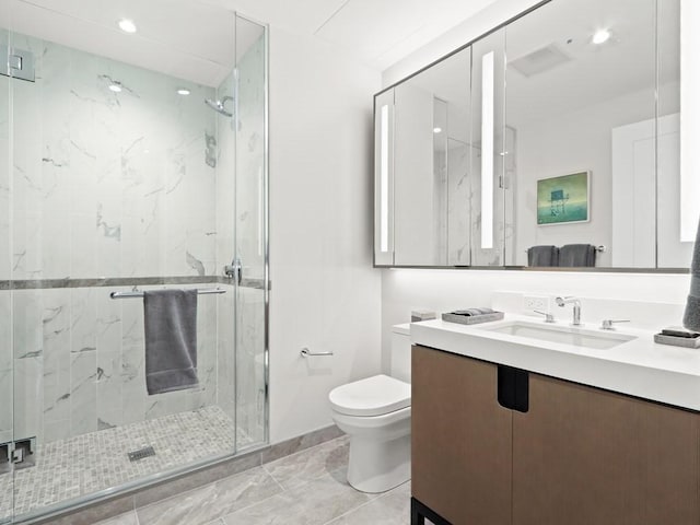 bathroom featuring vanity, toilet, and a shower with door