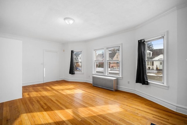 unfurnished room featuring crown molding, radiator heating unit, and wood-type flooring