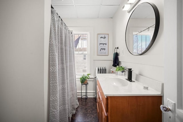 bathroom featuring vanity, radiator heating unit, and a paneled ceiling