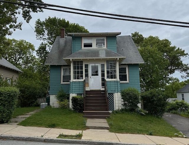 194 Fells Ave, Medford, MA 02155 - bungalow-style house featuring a chimney, roof with shingles, a front lawn, and cooling unit