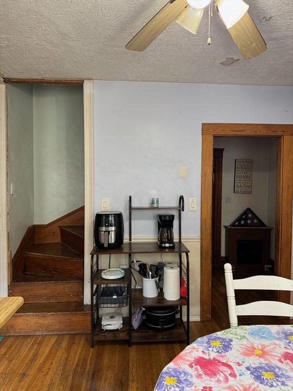 194 Fells Ave, Medford, MA 02155 - dining room featuring a textured ceiling, wood finished floors, a ceiling fan, and stairs