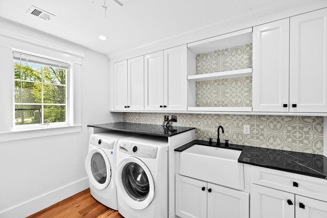 laundry area with cabinet space, washer and dryer, baseboards, wood finished floors, and recessed lighting