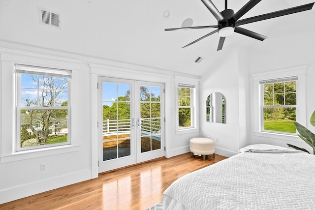 bedroom with access to exterior, french doors, lofted ceiling, wood finished floors, and baseboards
