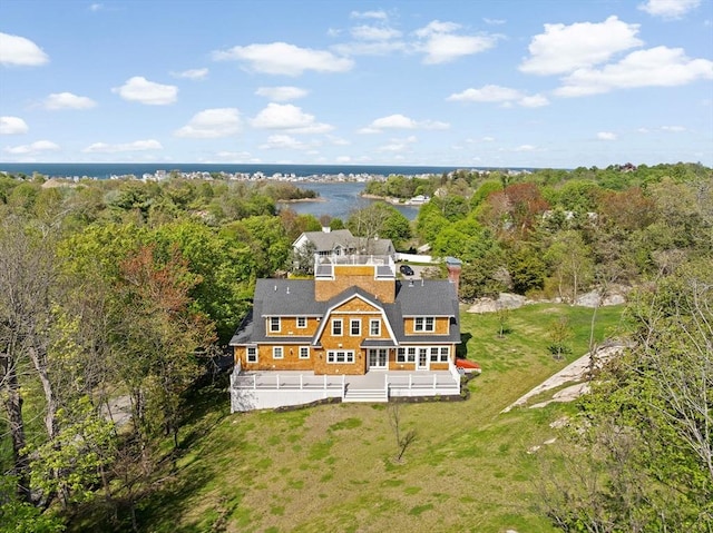 aerial view of property and surrounding area with a forest and a large body of water
