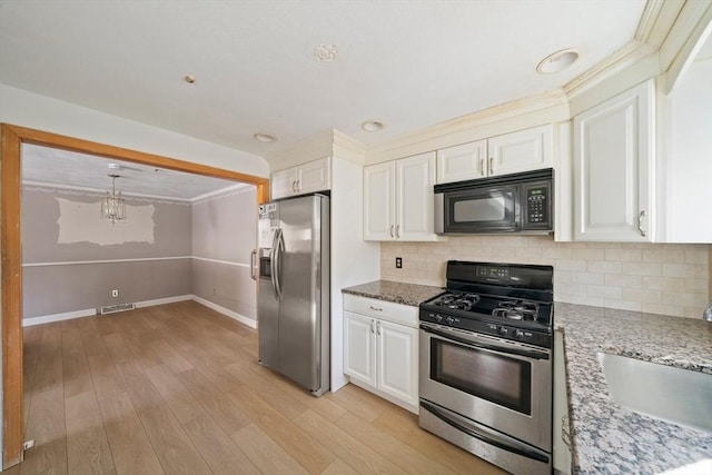 kitchen featuring stainless steel appliances, a sink, visible vents, and light stone countertops