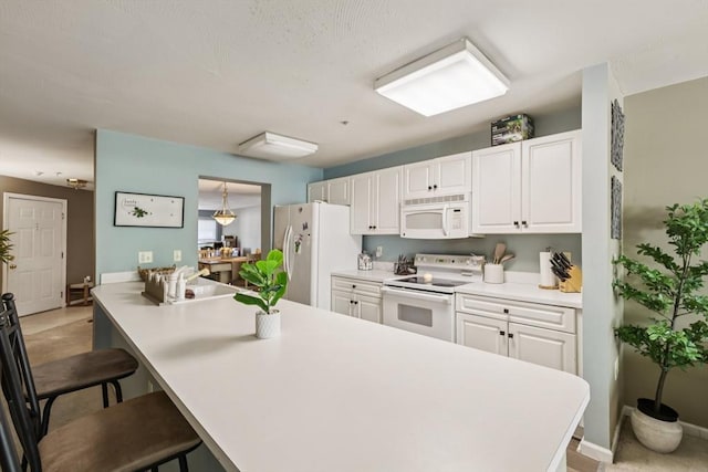 1 Riverview Blvd Unit 2-106, Methuen, MA 01844 - kitchen with white appliances, white cabinetry, a breakfast bar area, and light countertops