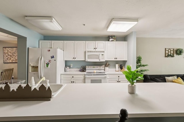 1 Riverview Blvd Unit 2-106, Methuen, MA 01844 - kitchen with white appliances, white cabinetry, and light countertops