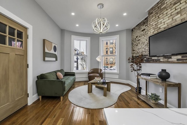 living area featuring baseboards, recessed lighting, an inviting chandelier, and dark wood-style floors