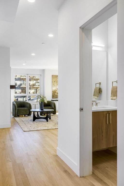 hall with sink and light hardwood / wood-style flooring