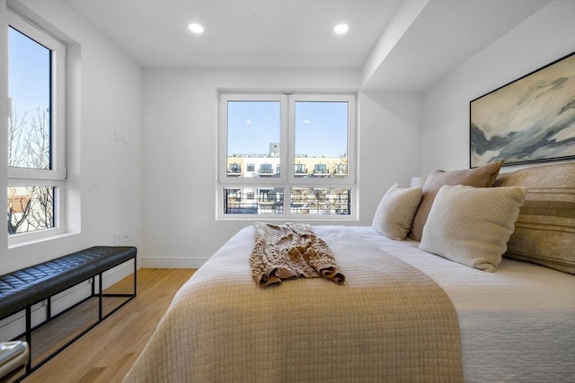 bedroom with multiple windows and light wood-type flooring