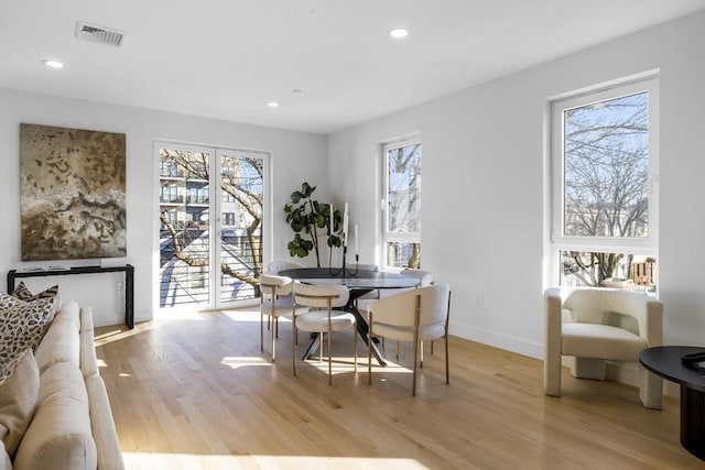 dining area with a wealth of natural light and light wood-type flooring