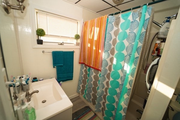 bathroom with curtained shower, hardwood / wood-style flooring, and vanity