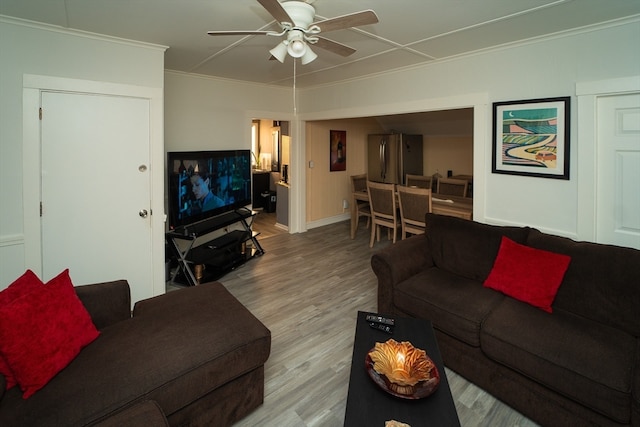 living room with ceiling fan, crown molding, and light hardwood / wood-style flooring