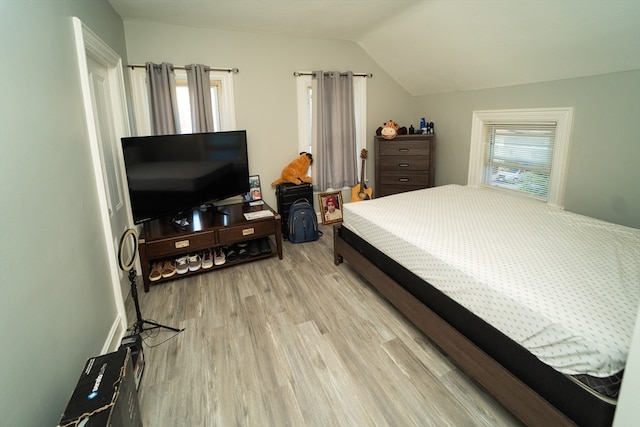 bedroom with lofted ceiling and light hardwood / wood-style flooring