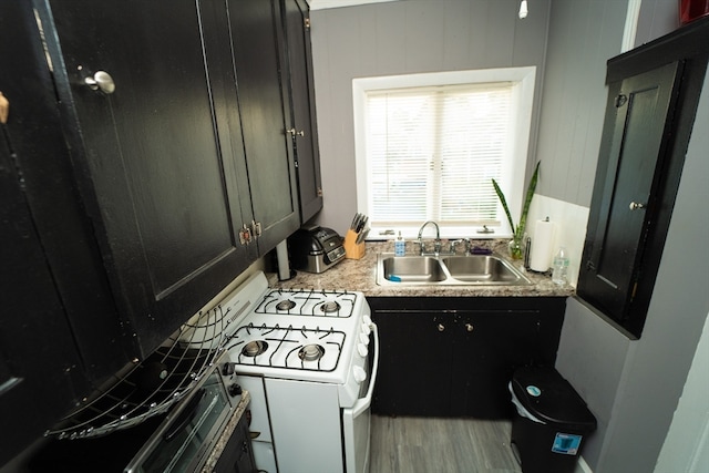 kitchen featuring white range with gas stovetop, light hardwood / wood-style flooring, and sink