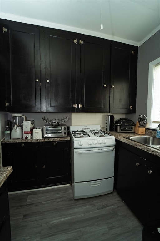 kitchen with crown molding, white range with gas stovetop, sink, and hardwood / wood-style flooring