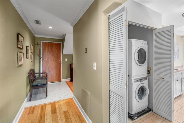 30 N Stone Ml Unit 1211, Dedham, MA 02026 - laundry area featuring laundry area, ornamental molding, visible vents, stacked washer / dryer, and baseboards