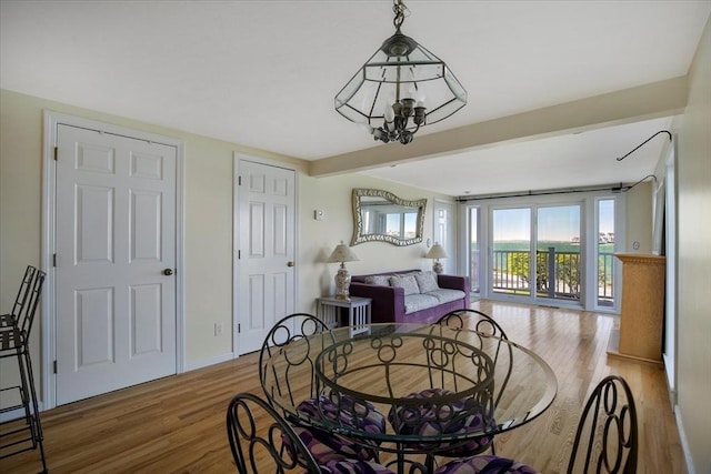 bedroom featuring baseboards, an inviting chandelier, and wood finished floors