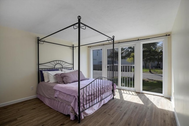 bedroom with access to outside, baseboards, and wood finished floors