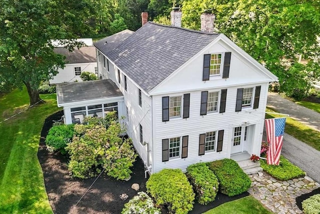 57 Highland St, Holden, MA 01520 - view of front of house featuring a chimney, a shingled roof, a sunroom, and a front yard