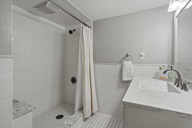 57 Highland St, Holden, MA 01520 - full bathroom with vanity, a tile shower, wainscoting, and tile walls