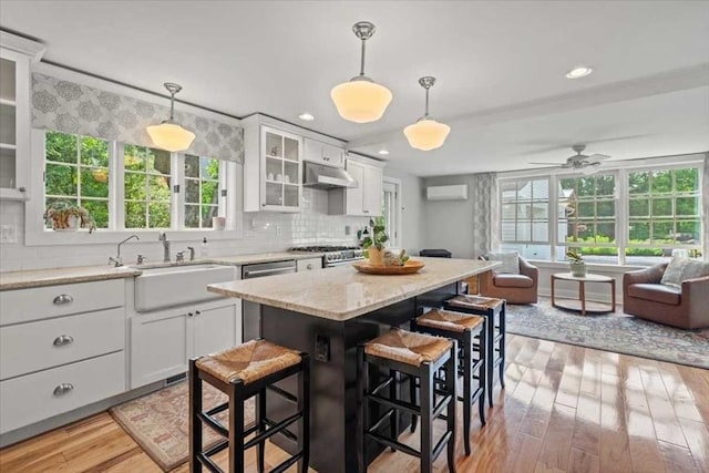 57 Highland St, Holden, MA 01520 - kitchen featuring a sink, range, light wood-style floors, white cabinetry, and open floor plan